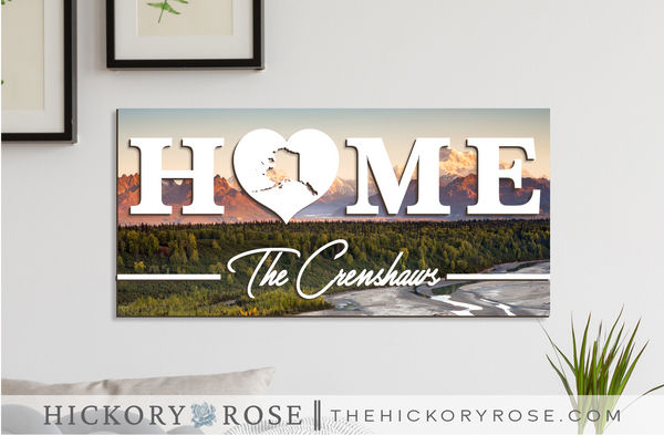 Alaska "HOME" sign with a background of the Denali mountain range, featuring Mt. McKinley